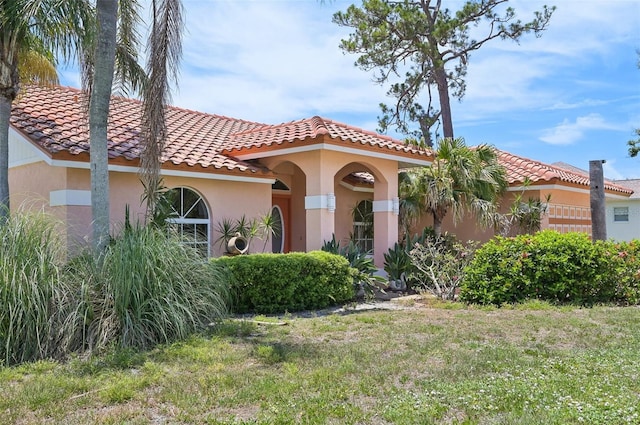321 Sorrento Dr, Osprey, FL 34229 - mediterranean / spanish house featuring stucco siding, a front lawn, and a tiled roof