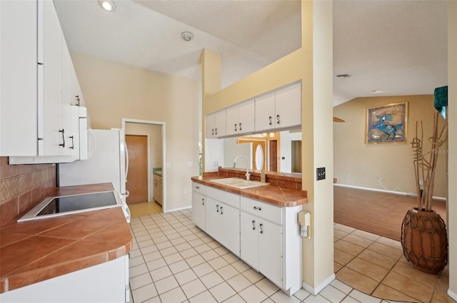 321 Sorrento Dr, Osprey, FL 34229 - kitchen with a sink, light tile patterned flooring, range, white cabinets, and lofted ceiling