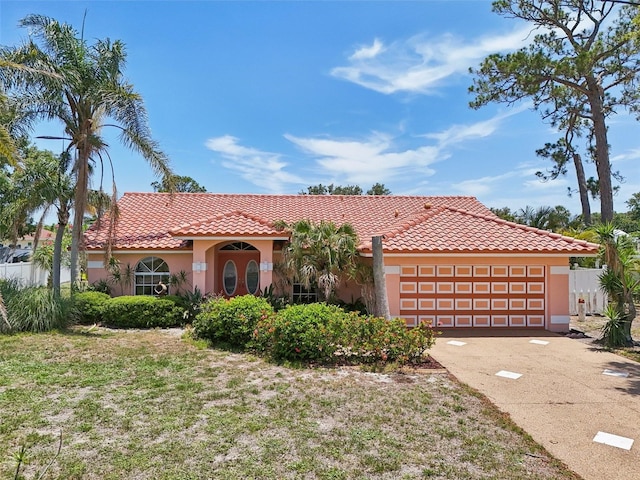 321 Sorrento Dr, Osprey, FL 34229 - mediterranean / spanish home with stucco siding, an attached garage, a tiled roof, and driveway