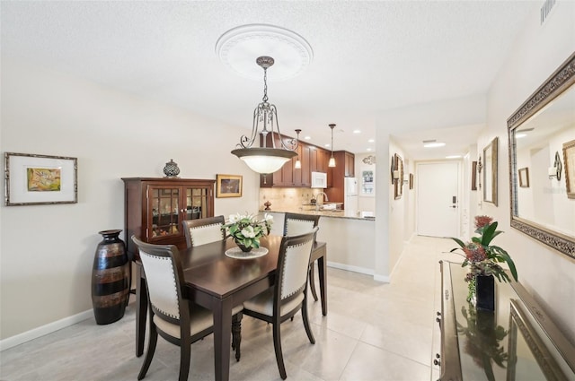 1170 Bird Bay Way Unit 206, Venice, FL 34285 - dining area with baseboards, recessed lighting, light tile patterned flooring, and a textured ceiling