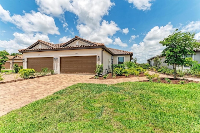 3027 Formia Ct, Lakewood Ranch, FL 34211 - mediterranean / spanish-style home with stucco siding, a front lawn, decorative driveway, a tile roof, and a garage