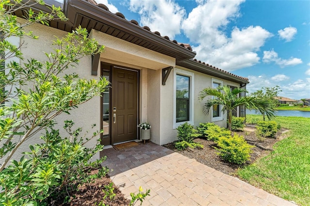 3027 Formia Ct, Lakewood Ranch, FL 34211 - doorway to property featuring stucco siding and a water view