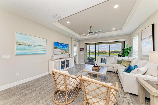 3027 Formia Ct, Lakewood Ranch, FL 34211 - living room with a raised ceiling, light wood-style floors, plenty of natural light, and recessed lighting