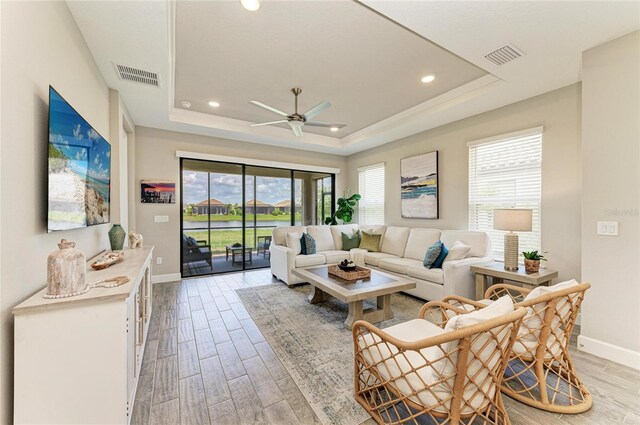 3027 Formia Ct, Lakewood Ranch, FL 34211 - living area with healthy amount of natural light, ceiling fan, light wood finished floors, a tray ceiling, and recessed lighting