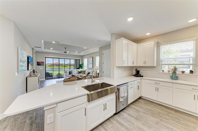 3027 Formia Ct, Lakewood Ranch, FL 34211 - kitchen with dishwasher, a raised ceiling, light wood finished floors, recessed lighting, and a peninsula