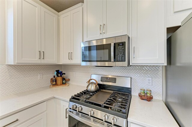 3027 Formia Ct, Lakewood Ranch, FL 34211 - kitchen with appliances with stainless steel finishes, tasteful backsplash, and white cabinetry