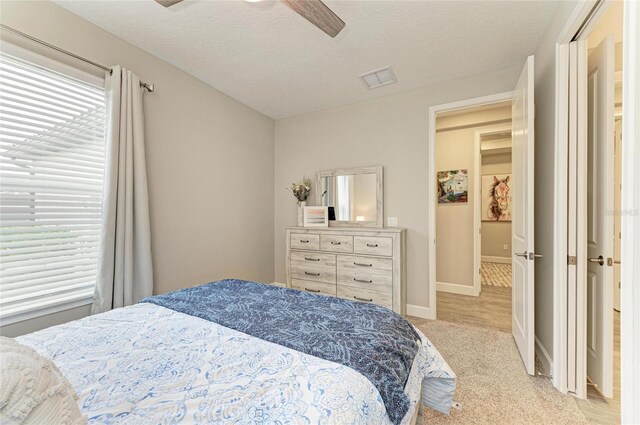 3027 Formia Ct, Lakewood Ranch, FL 34211 - bedroom featuring light carpet, a ceiling fan, and a textured ceiling