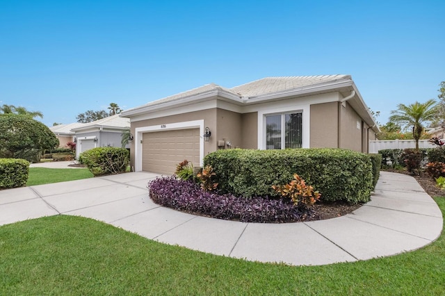 view of side of property featuring a garage, concrete driveway, stucco siding, and a tile roof