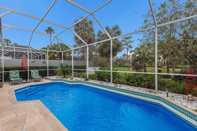 view of swimming pool with a patio area and a lanai