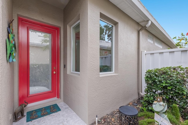 doorway to property featuring stucco siding