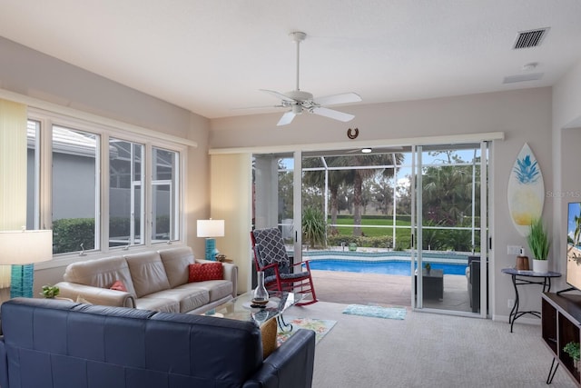living room featuring carpet and a ceiling fan