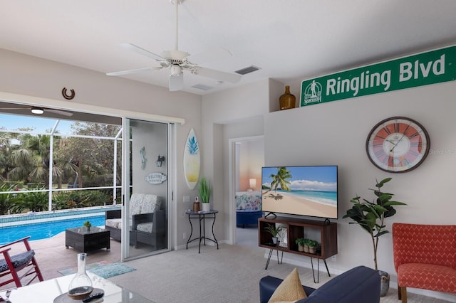 carpeted living room with ceiling fan and baseboards