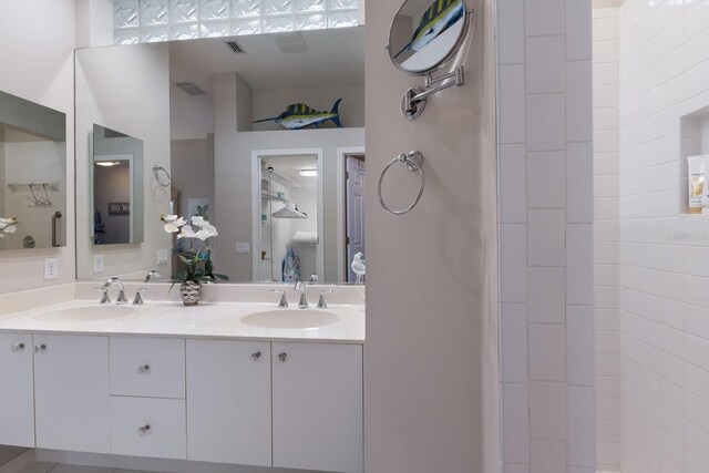 full bathroom with double vanity and tiled shower