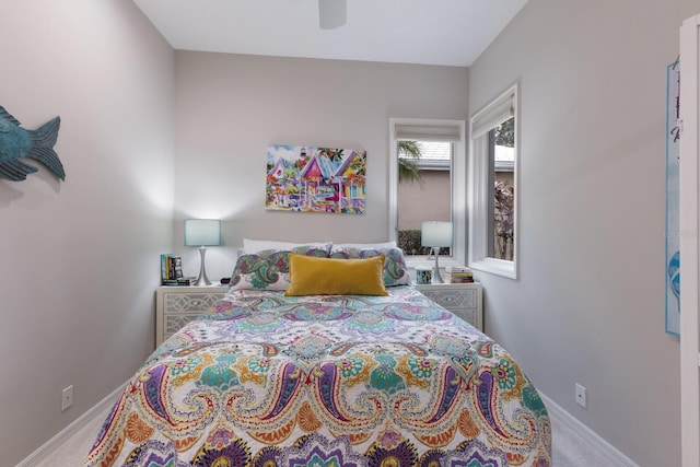 carpeted bedroom featuring baseboards and a ceiling fan