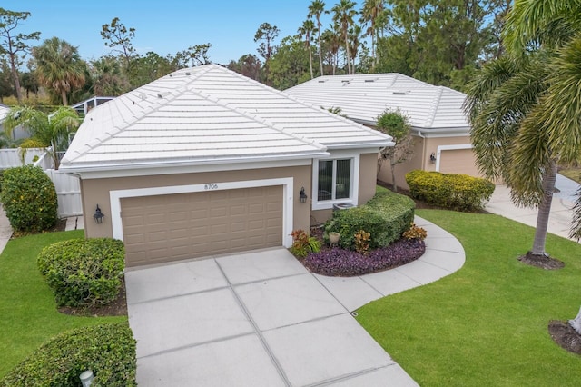 ranch-style home with a tiled roof, a front lawn, a garage, stucco siding, and driveway