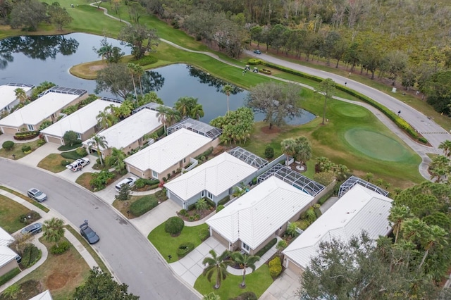 aerial view of property and surrounding area with a nearby body of water and a golf club