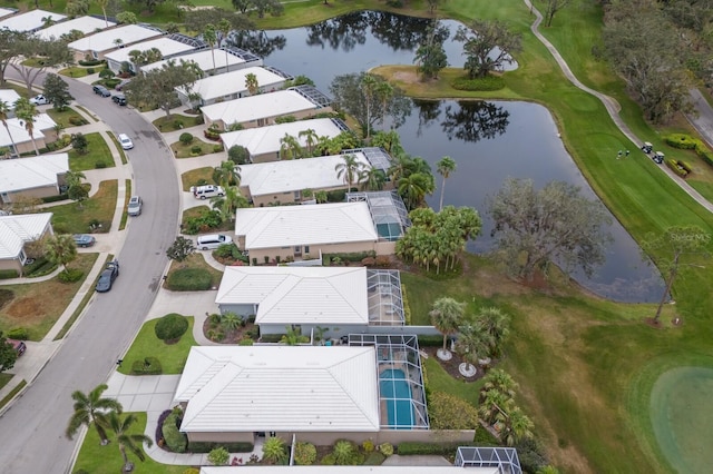 view of property location with a nearby body of water, a golf course, and nearby suburban area