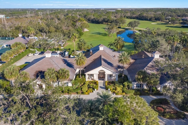 aerial overview of property's location featuring a golf course, a large body of water, and a tree filled landscape