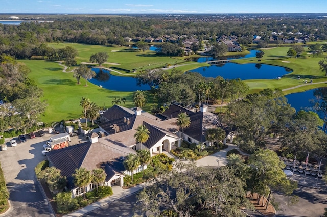 aerial view of a local golf course, a large body of water, and a tree filled landscape