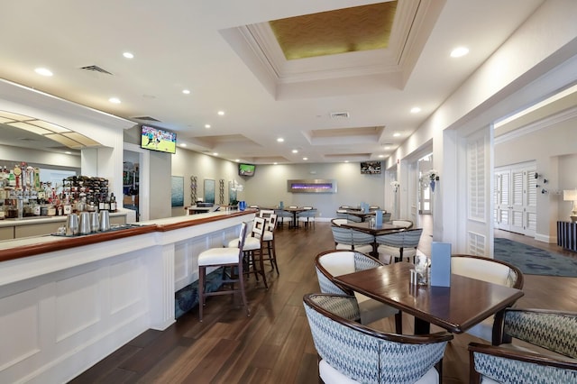 dining space featuring dark wood-style floors, a bar, crown molding, and recessed lighting