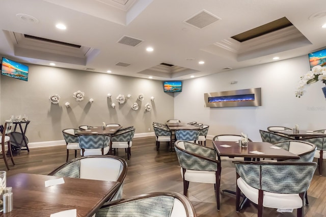 dining area featuring a tray ceiling, crown molding, wood finished floors, baseboards, and recessed lighting