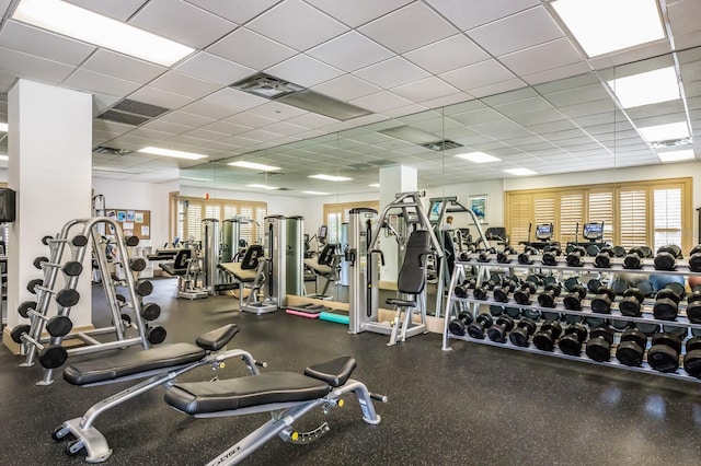 gym featuring plenty of natural light and a paneled ceiling