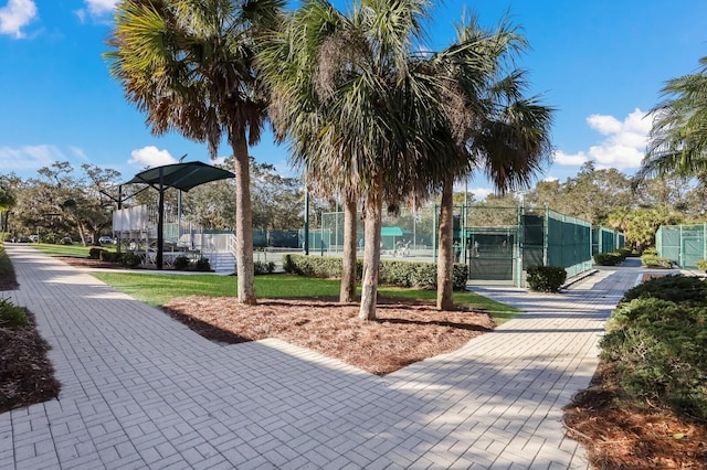 surrounding community with fence, a gate, and a tennis court