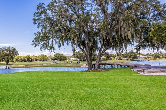 view of green lawn featuring a water view
