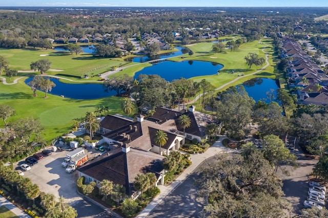 view of property location featuring a local golf course, nearby suburban area, and a nearby body of water