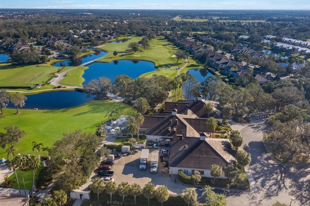 aerial view of property's location with a large body of water, a local golf course, and nearby suburban area