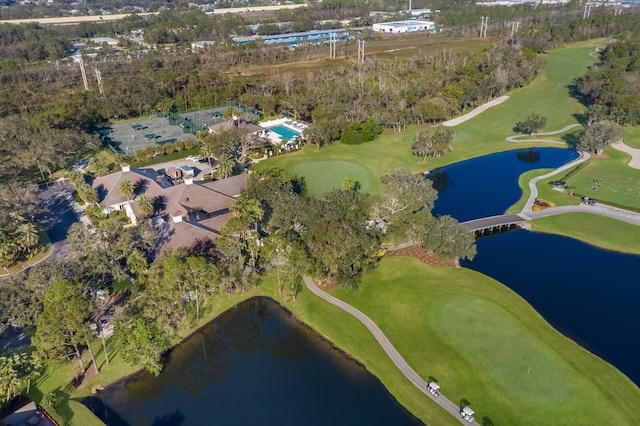 view of property location featuring a large body of water, a golf course, and a tree filled landscape