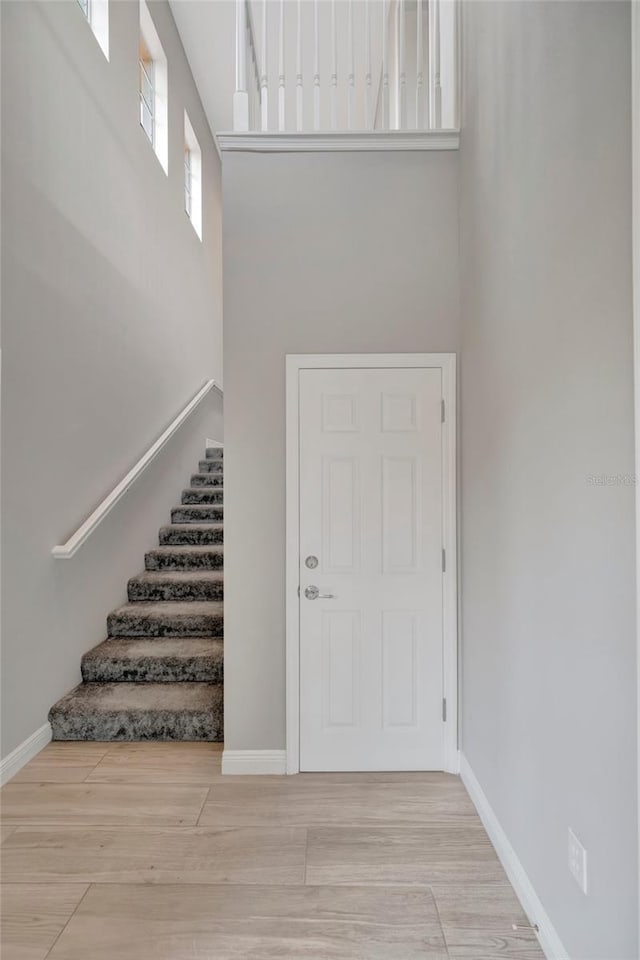 23233 Banbury Way Unit 302, Venice, FL 34293 - foyer entrance with a towering ceiling, stairway, wood finished floors, and baseboards