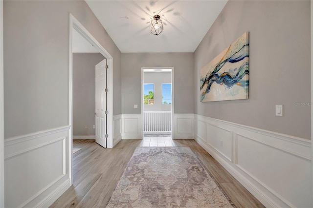 23233 Banbury Way Unit 302, Venice, FL 34293 - foyer with light wood-type flooring, wainscoting, and a decorative wall