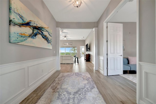 23233 Banbury Way Unit 302, Venice, FL 34293 - entryway with light wood-style flooring, ceiling fan, wainscoting, and a decorative wall