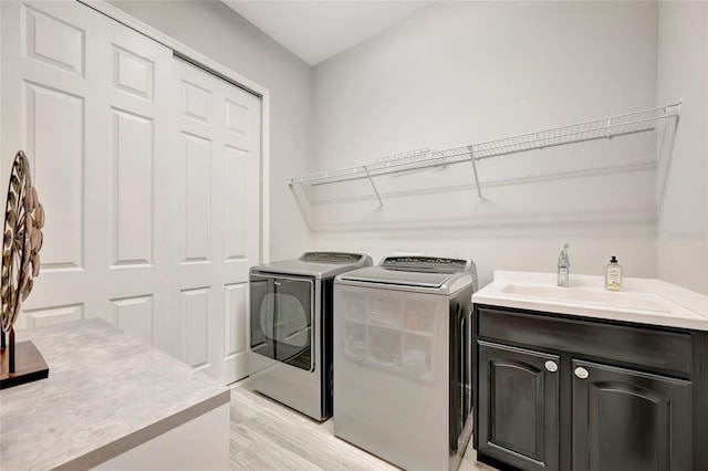 23233 Banbury Way Unit 302, Venice, FL 34293 - laundry room with washing machine and dryer, cabinet space, and light wood-style floors