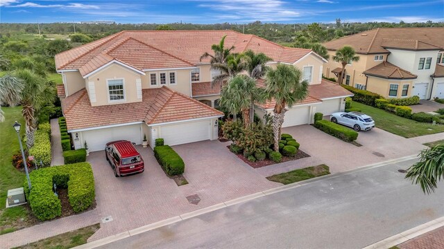 23233 Banbury Way Unit 302, Venice, FL 34293 - mediterranean / spanish-style house featuring a tile roof, decorative driveway, and stucco siding