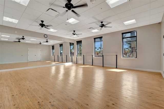 23233 Banbury Way Unit 302, Venice, FL 34293 - workout room featuring baseboards, light wood finished floors, and a paneled ceiling