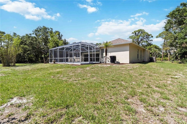 296 Pine Ranch Trl, Osprey, FL 34229 - back of house featuring stucco siding, a yard, and glass enclosure