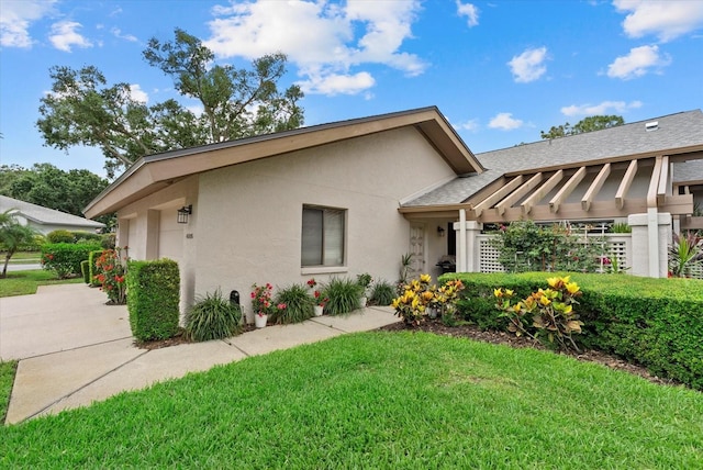 4505 Kingsmere Unit 2, Sarasota, FL 34235 - view of front of property featuring stucco siding, a front lawn, and a shingled roof