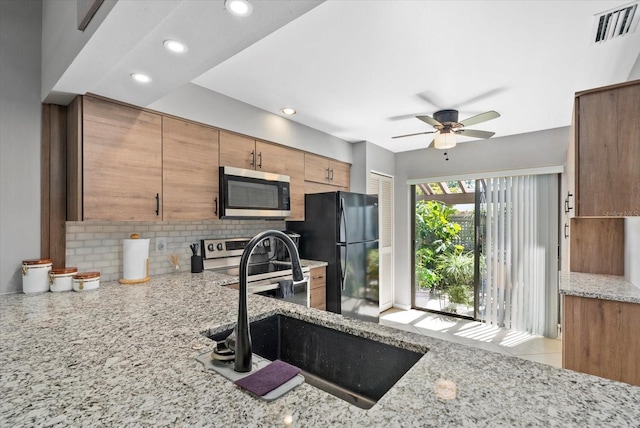 4505 Kingsmere Unit 2, Sarasota, FL 34235 - kitchen featuring stainless steel appliances, a sink, backsplash, ceiling fan, and light stone counters