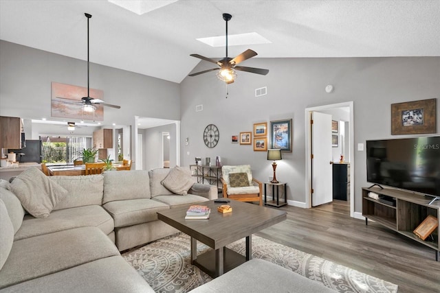 4505 Kingsmere Unit 2, Sarasota, FL 34235 - living area with a ceiling fan, light wood-type flooring, a skylight, high vaulted ceiling, and baseboards