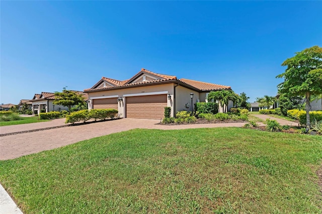 15707 Sacile Ln, Bradenton, FL 34211 - mediterranean / spanish home with a front lawn, a tile roof, decorative driveway, a garage, and stucco siding