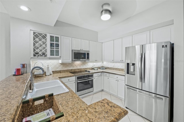1280 Dolphin Bay Way Unit 204, Sarasota, FL 34242 - kitchen featuring appliances with stainless steel finishes, a sink, tasteful backsplash, white cabinetry, and light tile patterned flooring