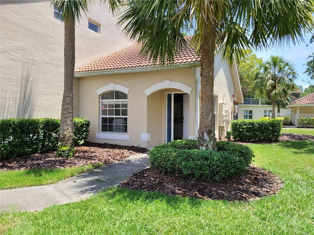 7273 Cedar Hollow Cir Unit 102, Bradenton, FL 34203 - doorway to property with stucco siding, a lawn, and a tiled roof