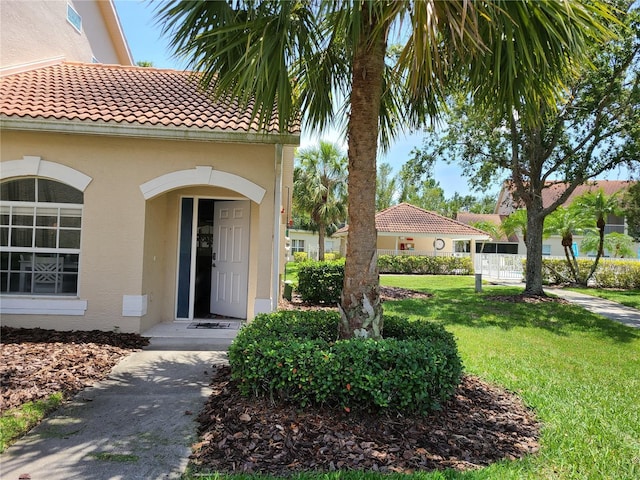 7273 Cedar Hollow Cir Unit 102, Bradenton, FL 34203 - property entrance with stucco siding, a lawn, and a tiled roof
