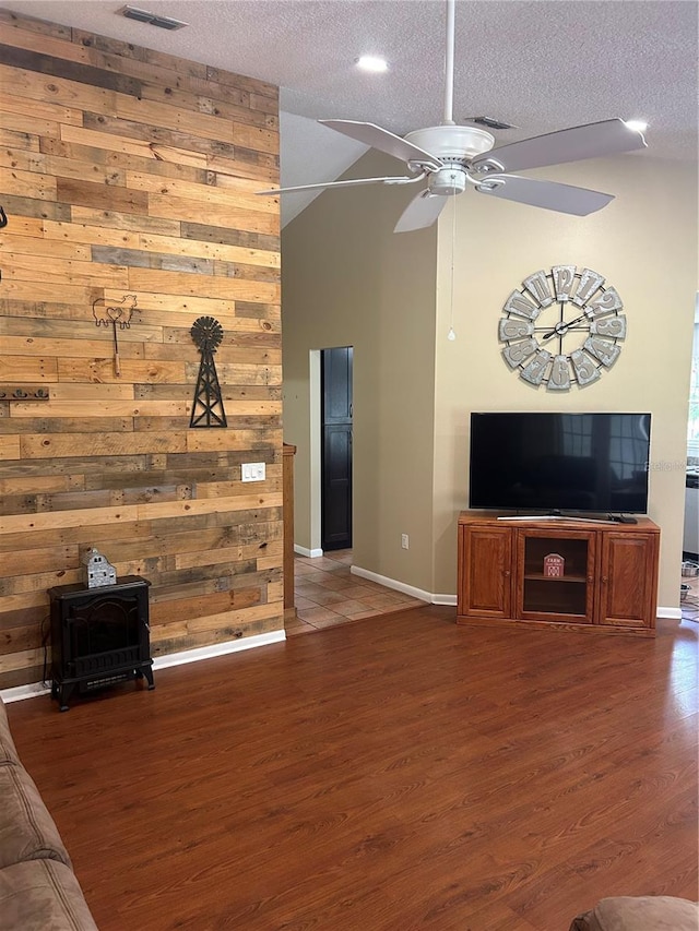 3287 Rackley Rd, Brooksville, FL 34604 - unfurnished living room featuring a wood stove, baseboards, ceiling fan, wood finished floors, and a textured ceiling