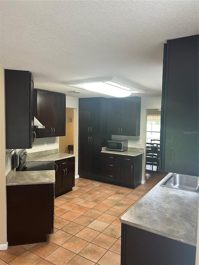 3287 Rackley Rd, Brooksville, FL 34604 - kitchen with stainless steel microwave, exhaust hood, light countertops, a textured ceiling, and light tile patterned floors