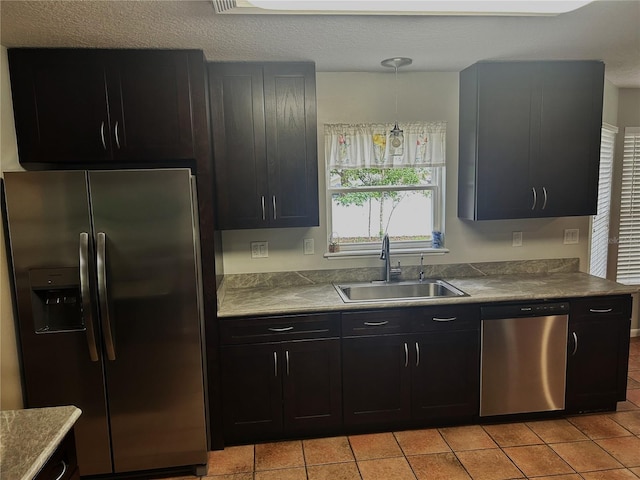 3287 Rackley Rd, Brooksville, FL 34604 - kitchen featuring appliances with stainless steel finishes, a sink, dark cabinetry, light tile patterned floors, and a textured ceiling
