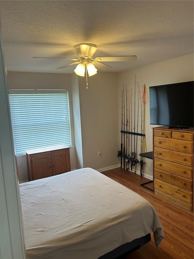 3287 Rackley Rd, Brooksville, FL 34604 - bedroom with wood finished floors, a textured ceiling, a ceiling fan, and baseboards