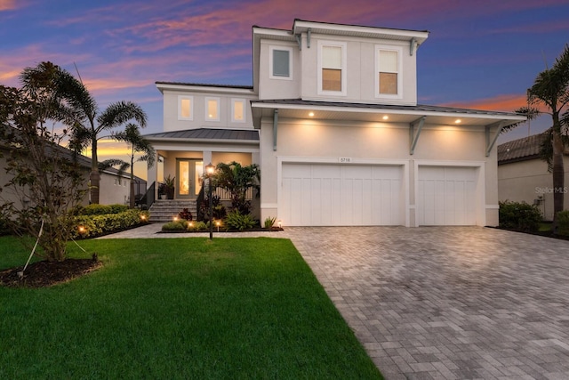 5718 Title Row Dr, Bradenton, FL 34210 - view of front of home with a standing seam roof, decorative driveway, a garage, stucco siding, and a porch